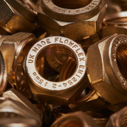 A close-up image of multiple brass nuts, each stamped with the Flowflex brand