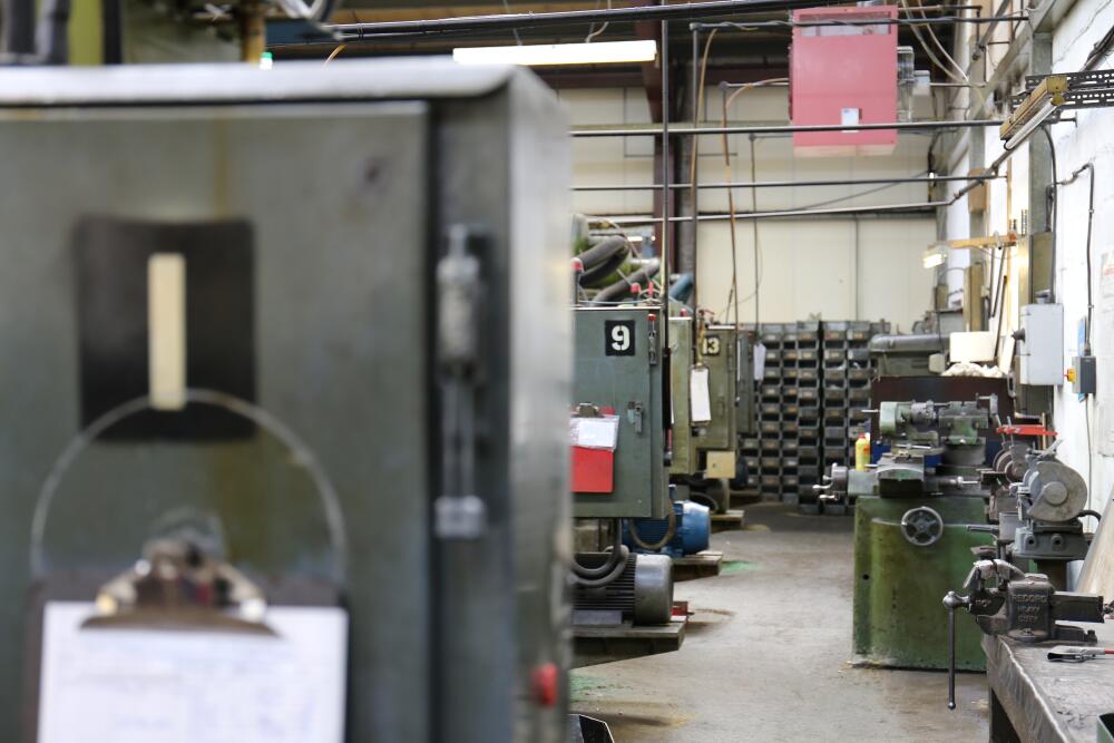 An interior view of a machine shop with various pieces of industrial equipment and machinery. Indicates a busy manufacturing environment, showcasing Flowflex manufacturing capabilities.