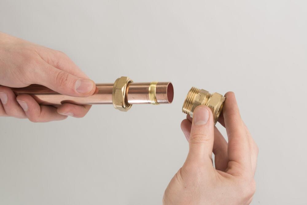 Installer assembling fittings on copper pipe